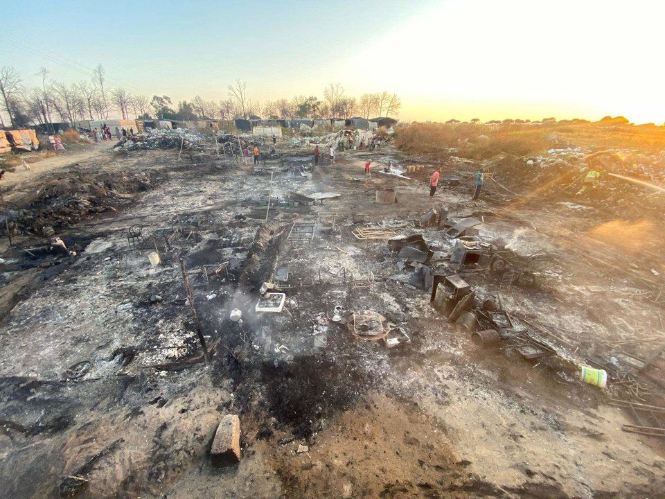 Residentes buscan sus pertenencias tras el fuego que devoró el campamento